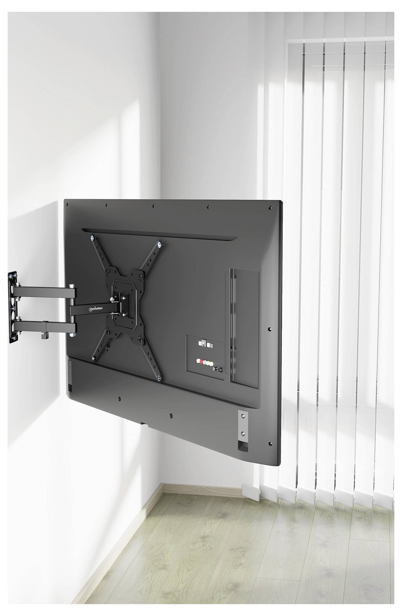 En platt-TV monterad på en vägg med ett justerbart fäste, placerad till vänster och vinklad inåt i ett ljust rum med persienner.