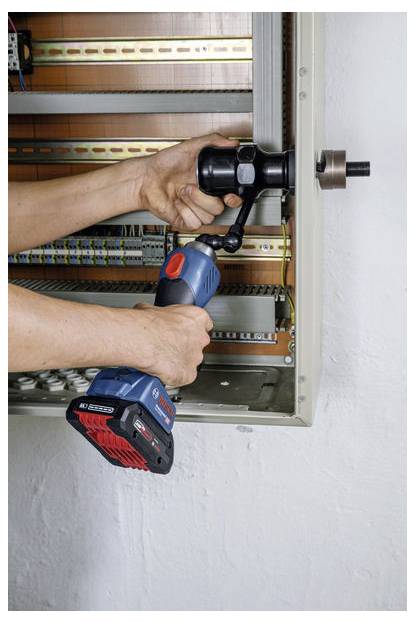 En person använder en elektrisk borr för att installera en komponent i en elcentral, med fokus på detaljerat manuellt arbete med synliga ledningar.