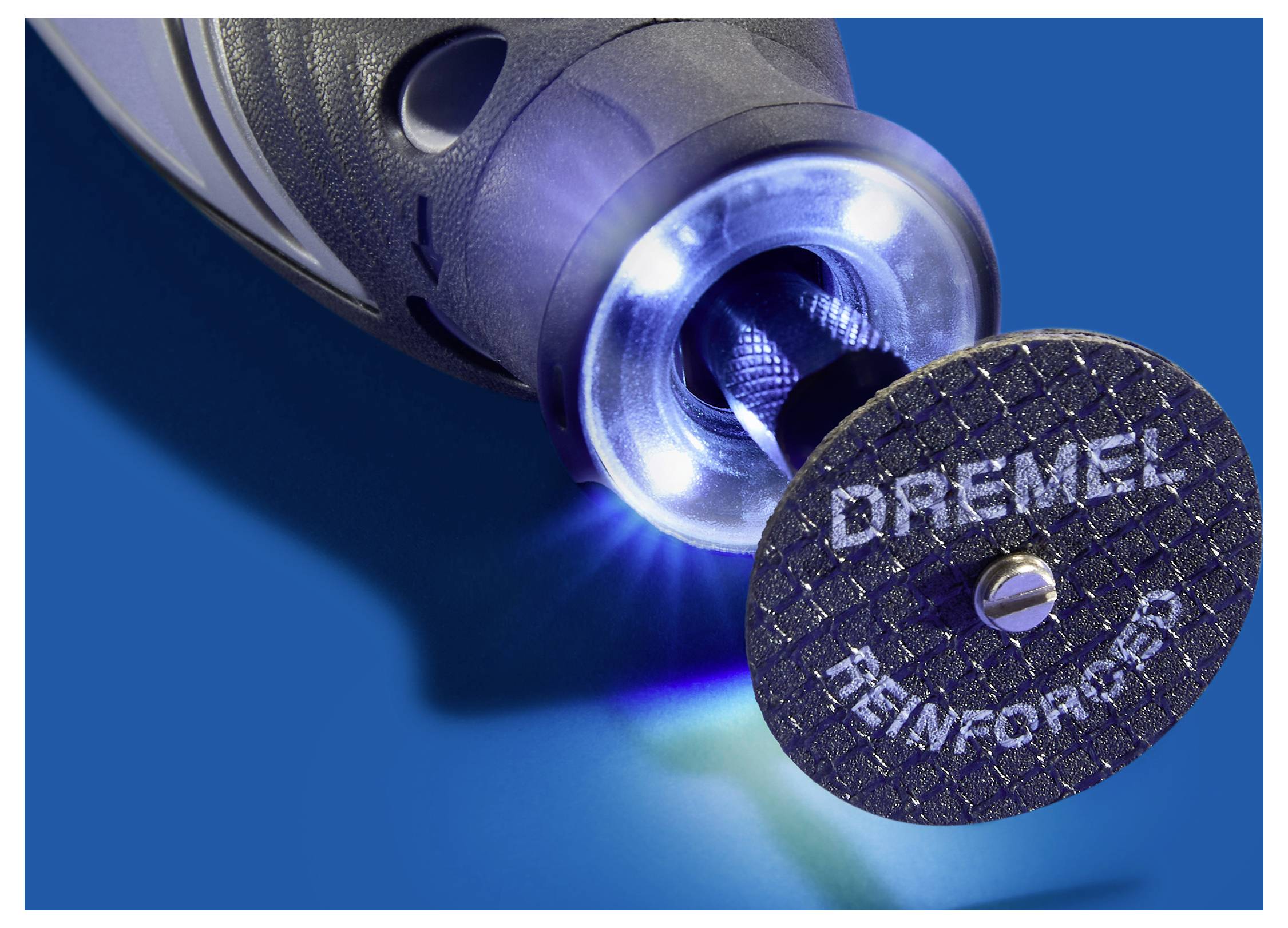 En närbild av ett Dremel roterande verktyg med en påsatt förstärkt skärskiva, upplyst av omgivande LED-lampor, som framhäver verktygets precision.