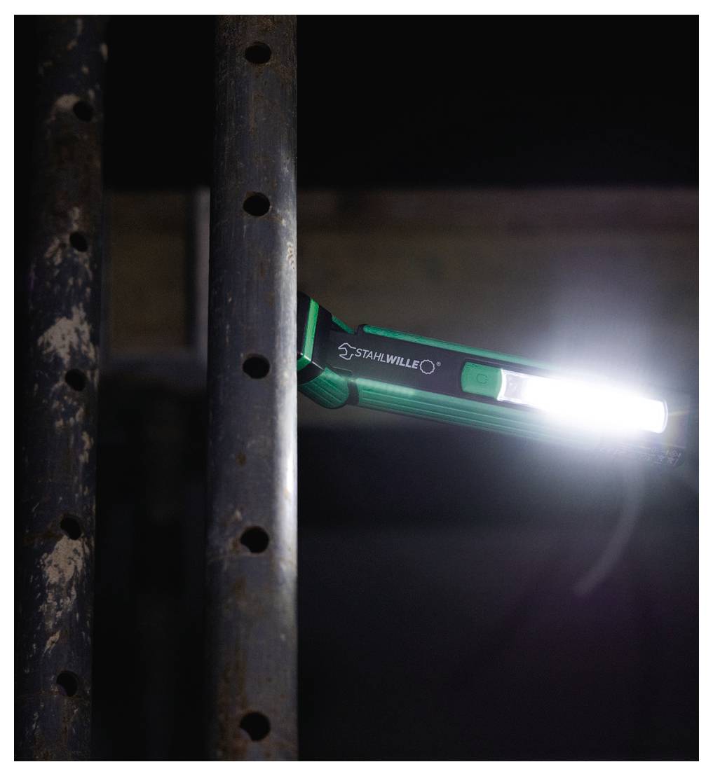 En STARWILLE-ficklampa lyser upp en metallstång med hål, vilket antyder användning i en mörk miljö eller för detaljerad inspektion.