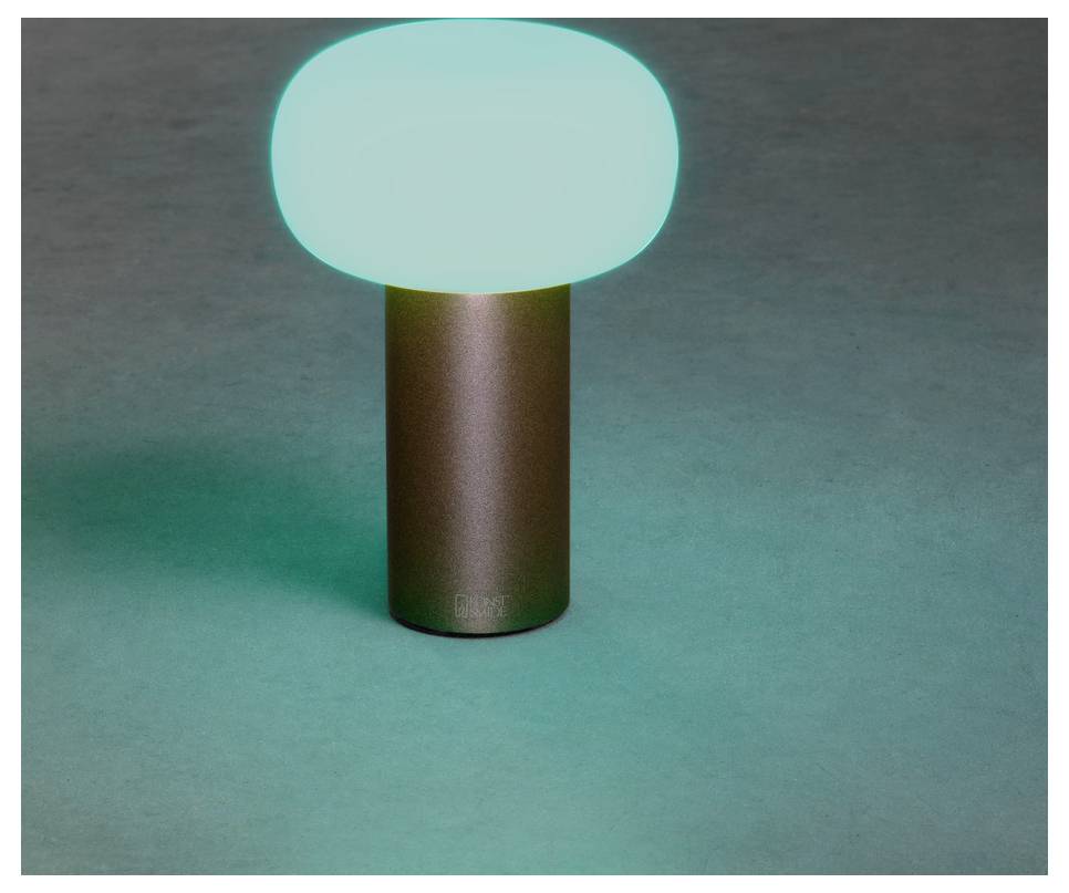 En liten bordslampa med en lysande, rund, grön skärm på en cylindrisk brun bas placerad på en neutralfärgad yta.