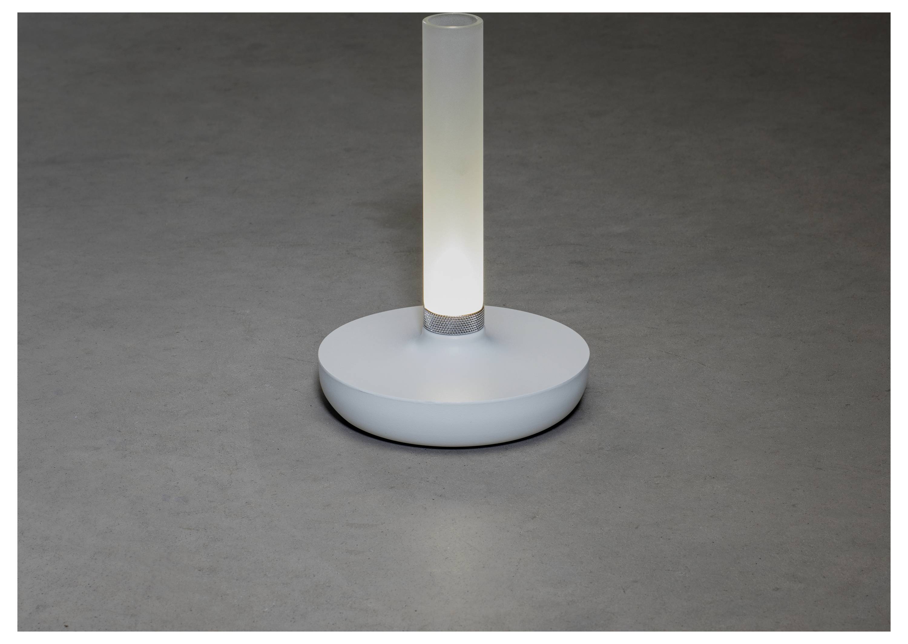 En smidig, modern bordslampa med en cylindrisk, upplyst glastopp på en cirkelformad bas, placerad på en slät grå yta.