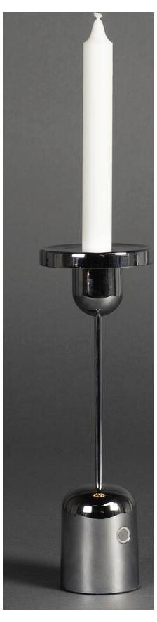 Ett högt, vitt ljus placeras i en elegant, modern silverljusstake mot en mörkgrå bakgrund.
