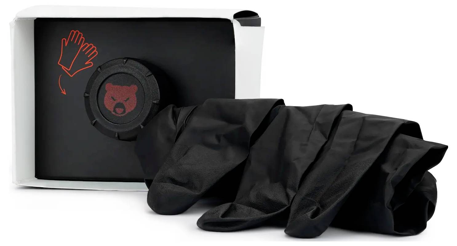 En låda som innehåller svarta handskar med en röd symbol föreställande ett björnhuvud och en ikon av handskar på lådan.