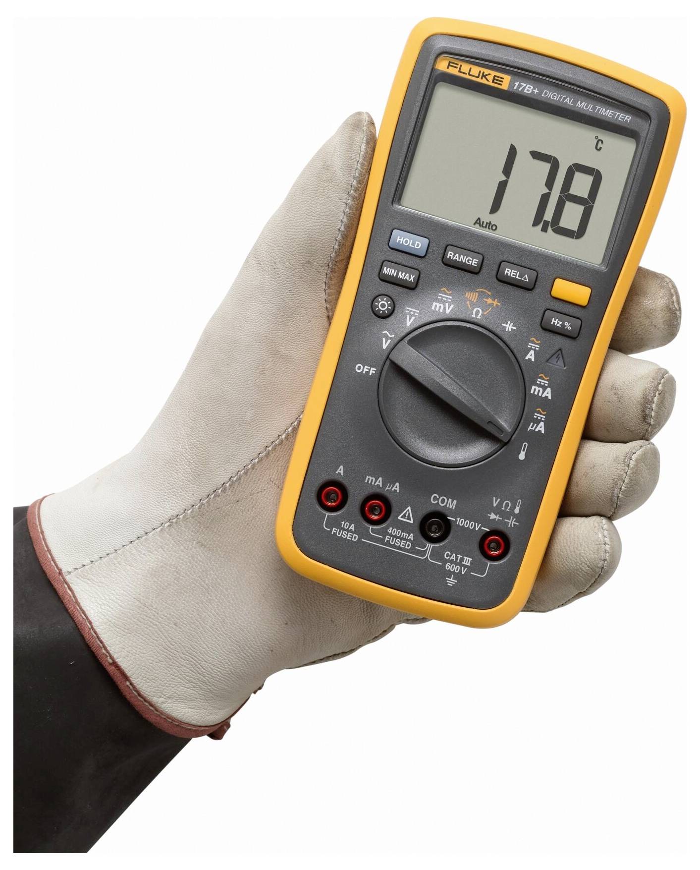 En hand i en handske håller en digital multimeter som visar 17,8. Multimetern har olika inställningar och ett orange skyddande hölje.