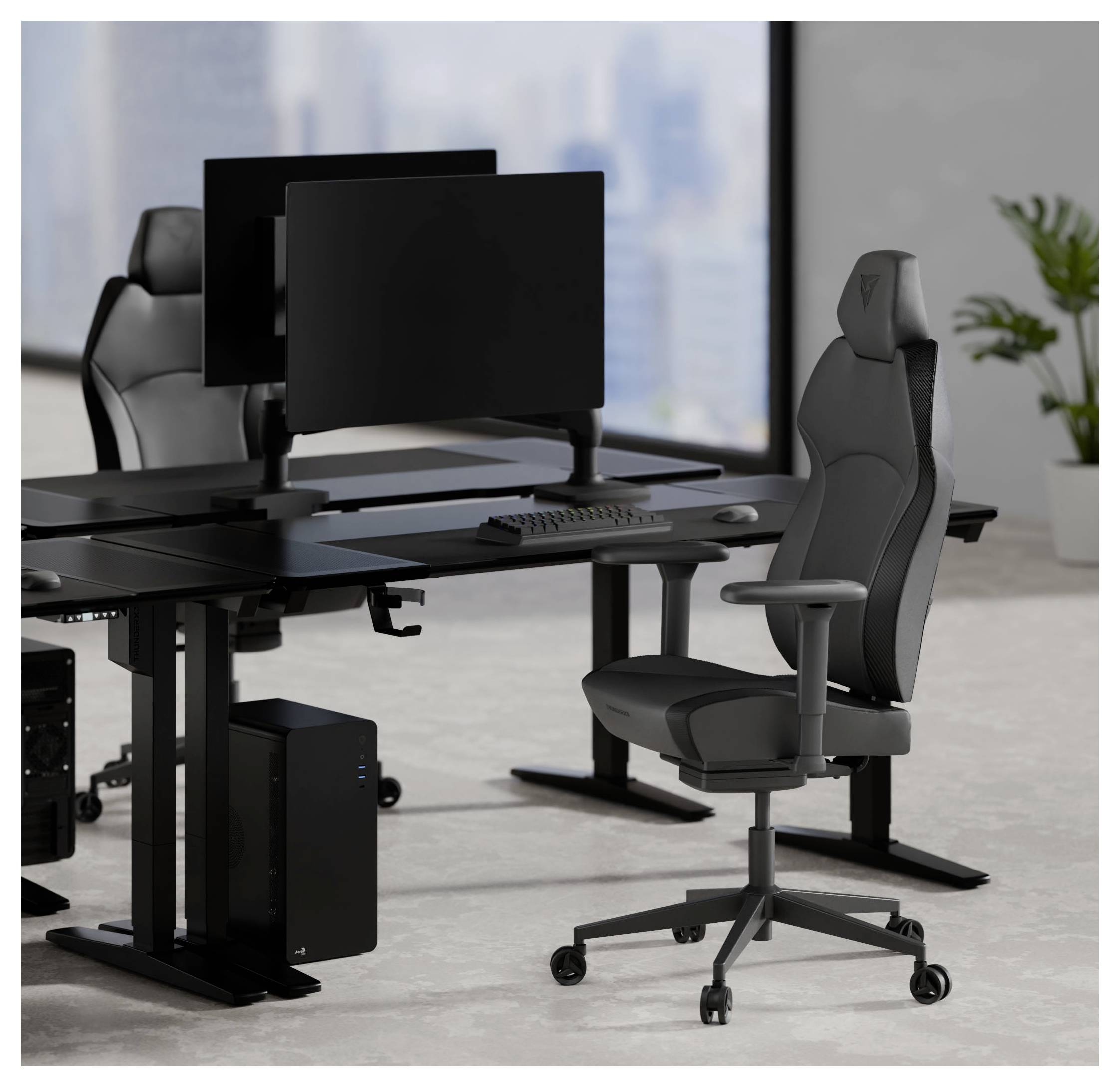 Två moderna svarta kontorsbord med dubbla skärmar, ett tangentbord och ergonomiska stolar i ett ljust rum med utsikt över en stadssilhuett.