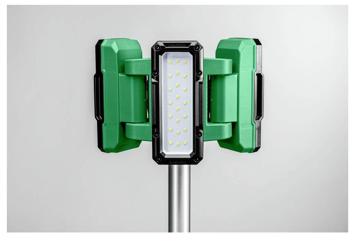 En grön och svart LED-arbetslampa på ett metallstativ, med flera små LED-lampor på en rektangulär panel, mot en enkel bakgrund.