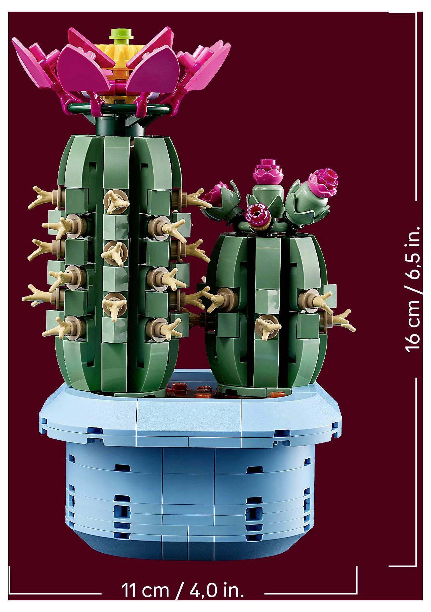 Två gröna LEGO-kaktusar i en blå kruka; en har rosa blommor på toppen. Dimensioner: 16 cm (höjd), 11 cm (bredd).