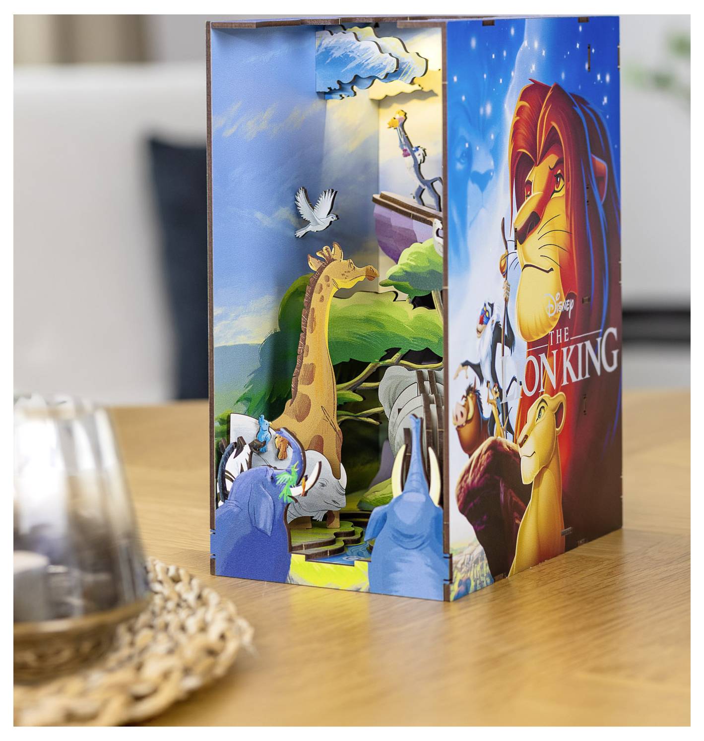 En 3D-popup-scen från 'Lejonkungen' med animerade karaktärer som en lejon och giraffer på en färgstark, levande bakgrund.