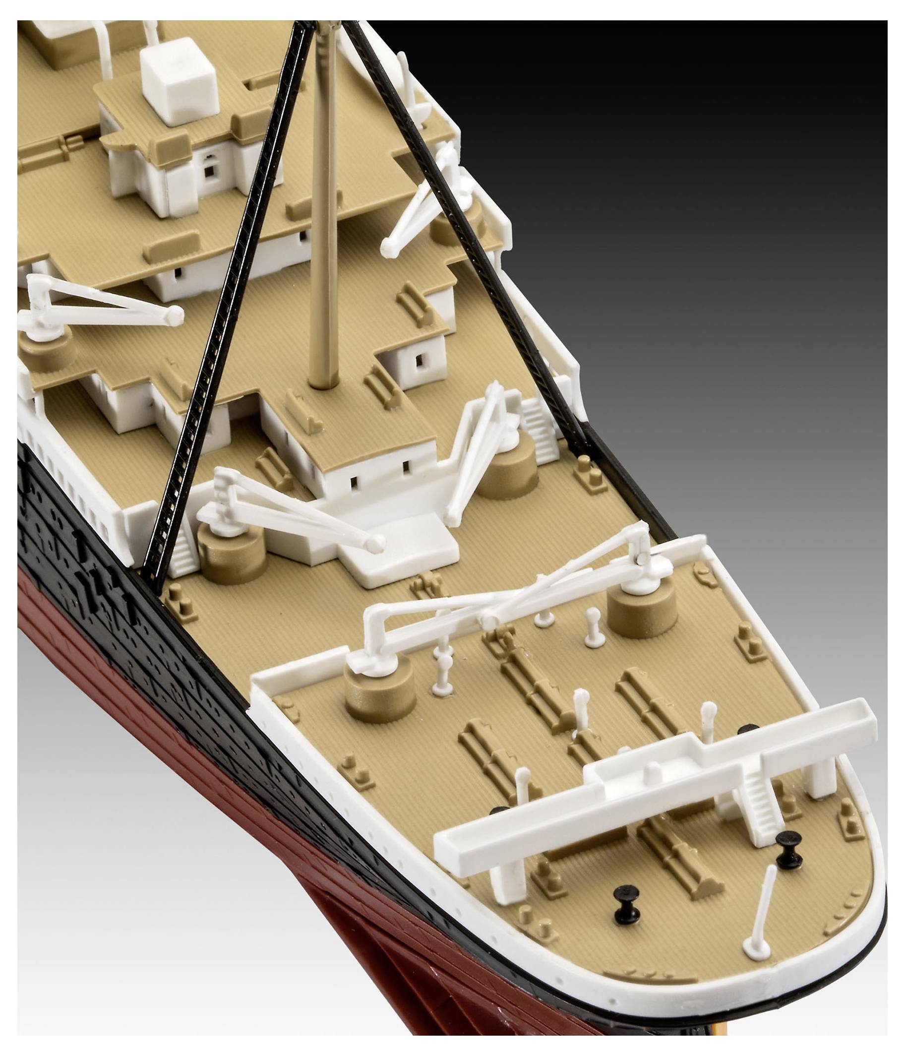 En närbild av en modellskeppsdäck med livbåtar, master och detaljerat riggverk på en neutral bakgrund, som framhäver maritim design.