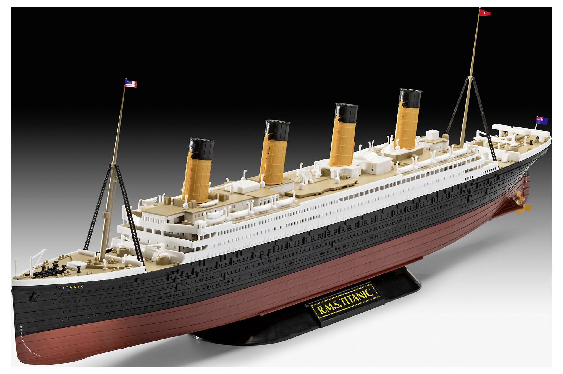 En detaljerad modell av RMS Titanic med fyra skorstenar, med röd skrov och vit överbyggnad, placerad på ett ställ.