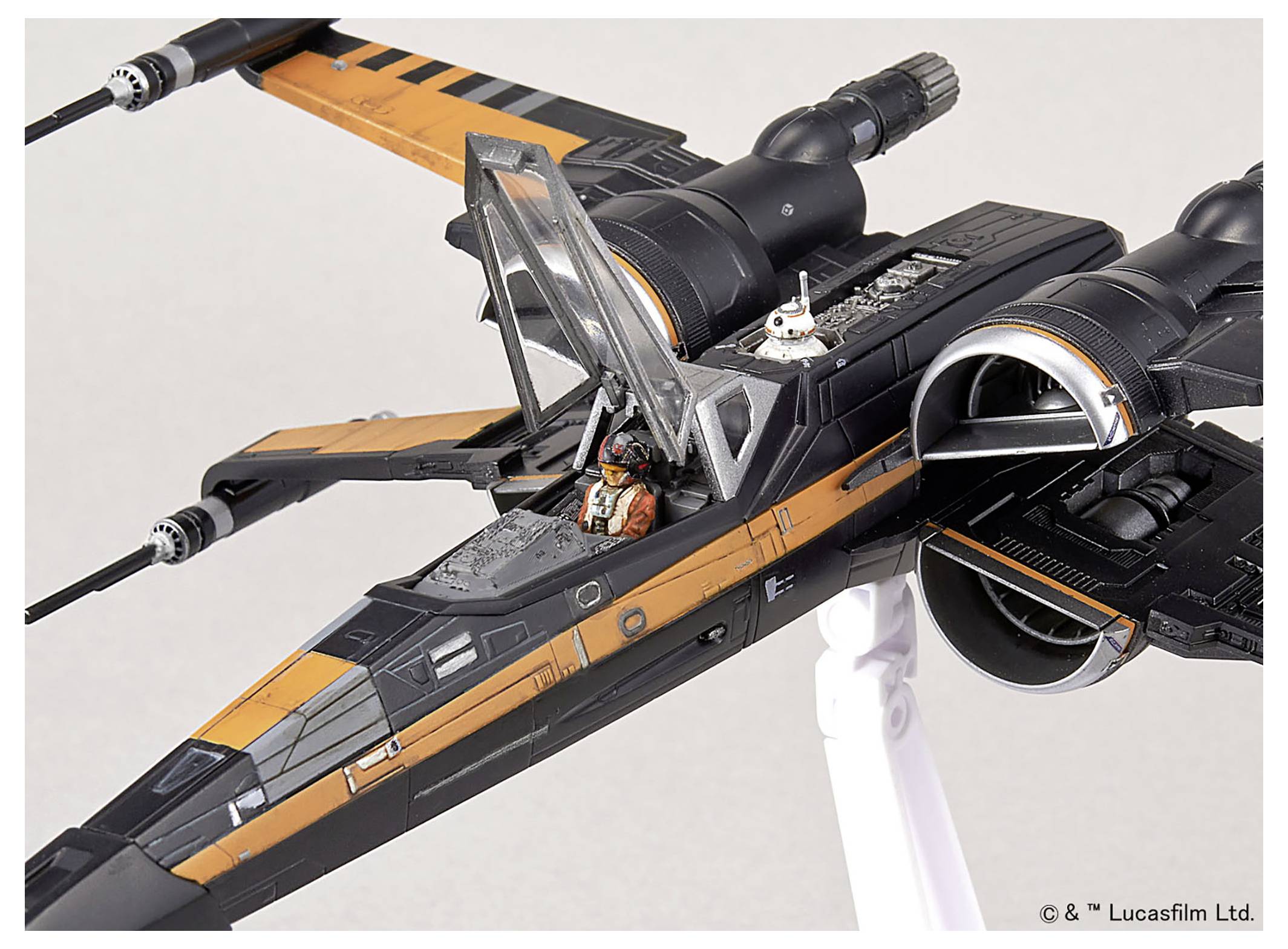 En modell av ett X-wing rymdskepp med en öppen cockpit, som visar en pilotfigur inuti och en astromekdroid bakom cockpiten.