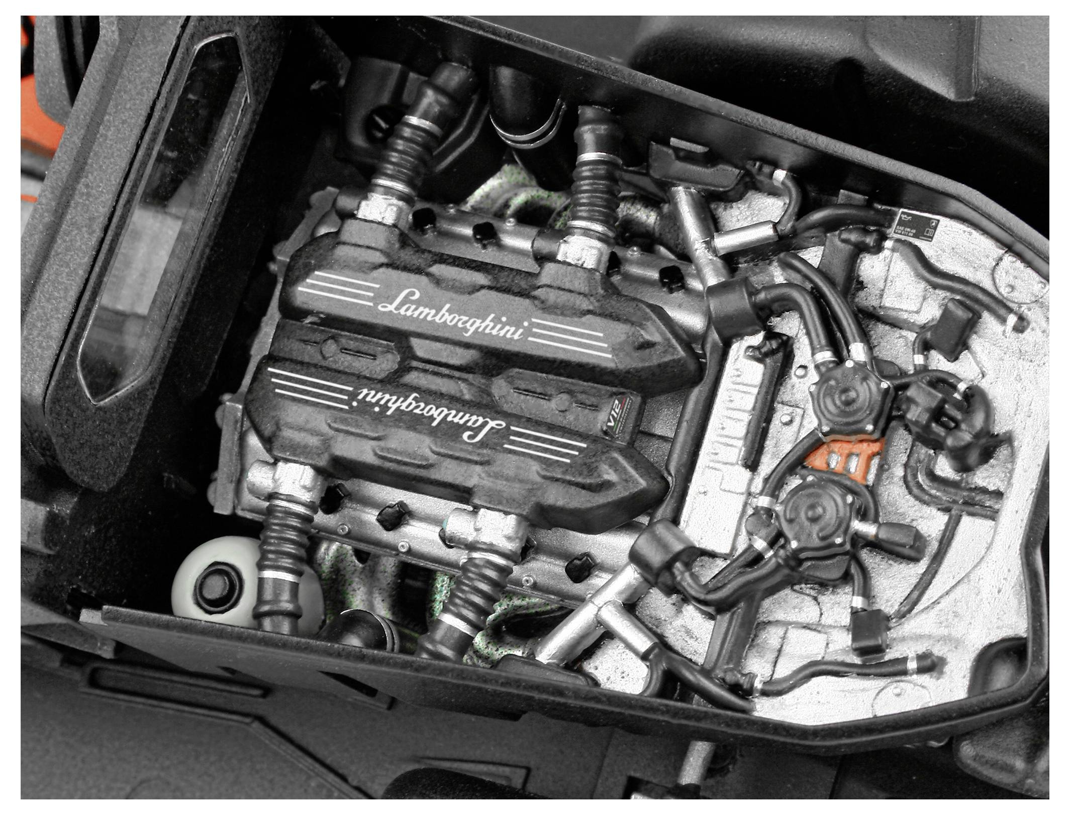 Närbild av en Lamborghini-motor, som visar detaljerade komponenter och varumärkets logotyp på motorkåpan.