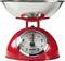 En röd analog köksvåg med en stor metallskål ovanpå och en urtavla som visar vikt i kilogram och gram, upp till 5 kg.