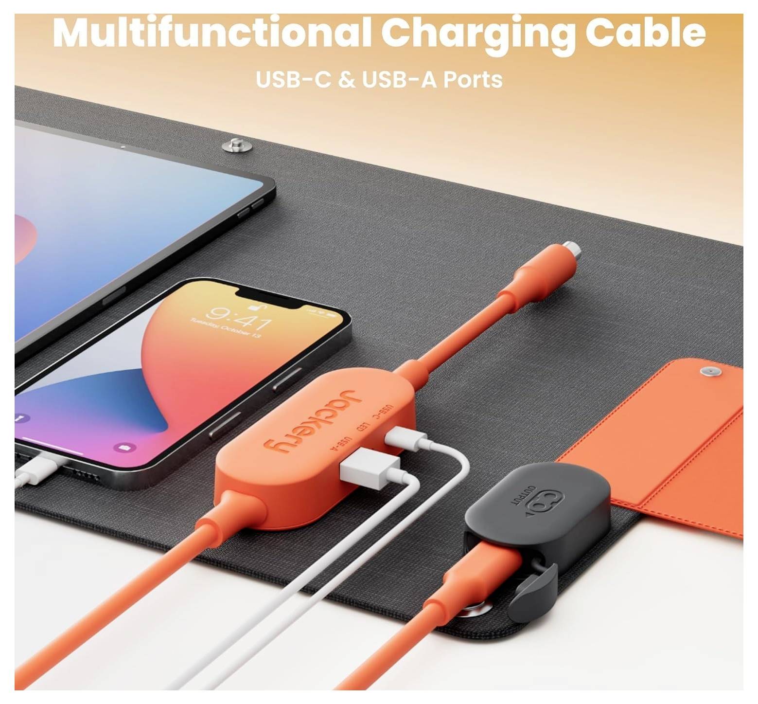 Mångfunktionell laddningskabel med USB-C och USB-A-portar, som visas medan den laddar en smartphone och en annan enhet, på ett skrivbordsunderlägg.
