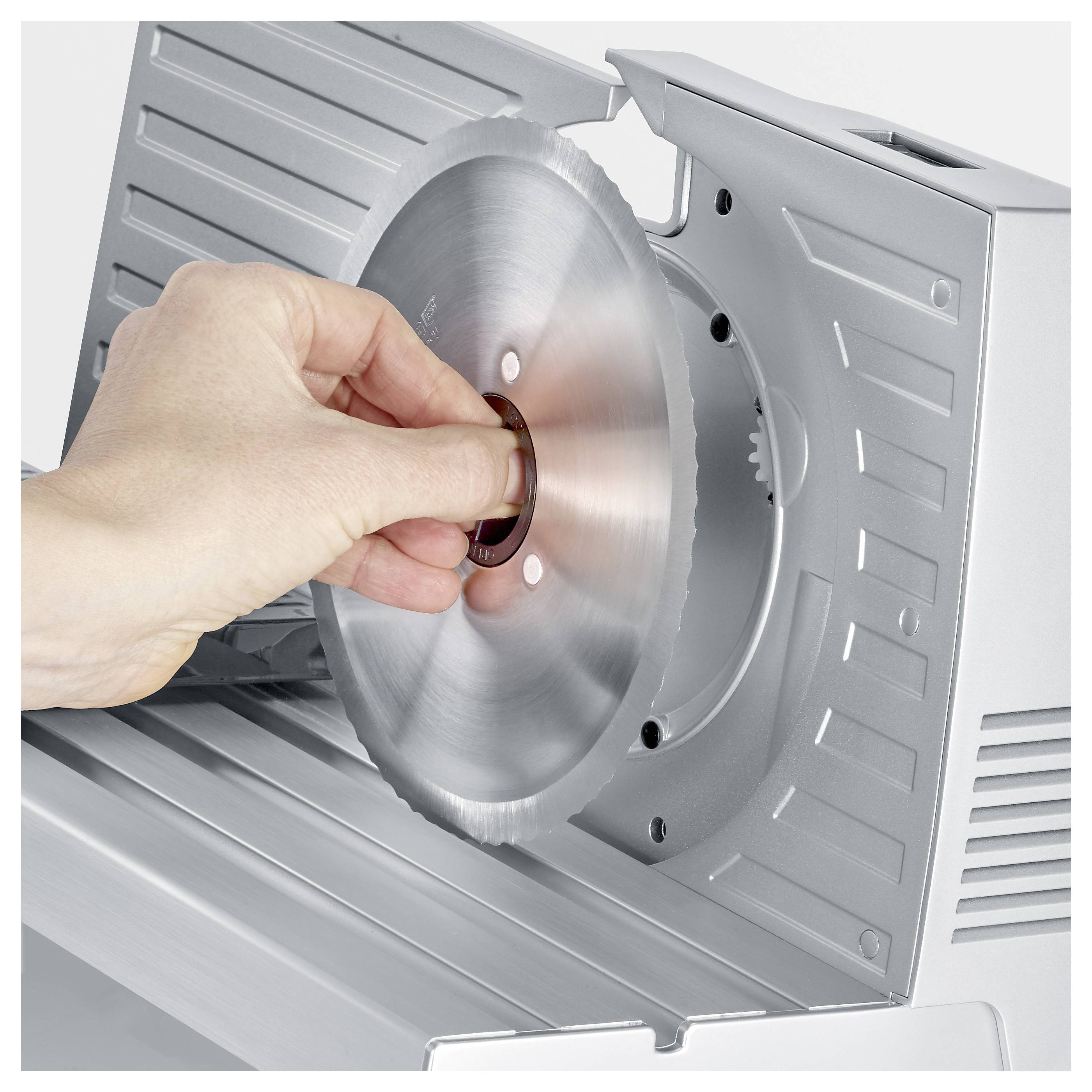 Handsäker borttagning av blad från köttskärare för rengöring.