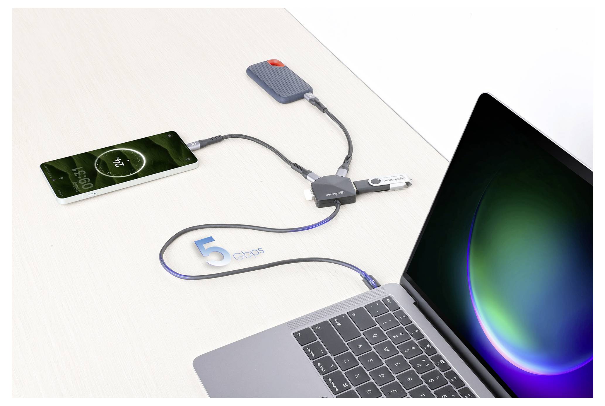 En bärbar dator ansluten till en USB-hubb med tre enheter: en smartphone som laddar, en portabel hårddisk och en USB-minnesstick. En etikett med "5 Gbps" är synlig.