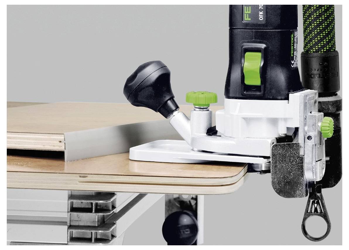 En närbild visar ett routerverktyg i bruk som trimmar kanten på en träbräda på en arbetsbänk, vilket framhäver hantverksskicklighet inom träbearbetning.