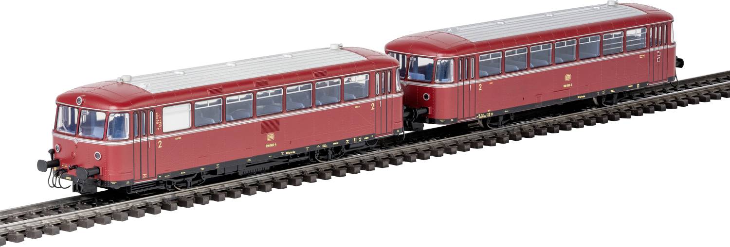 Två röda vintage-tågvagnar på spår, som visar detaljerade fönster- och takdesigner, placerade ände mot ände.