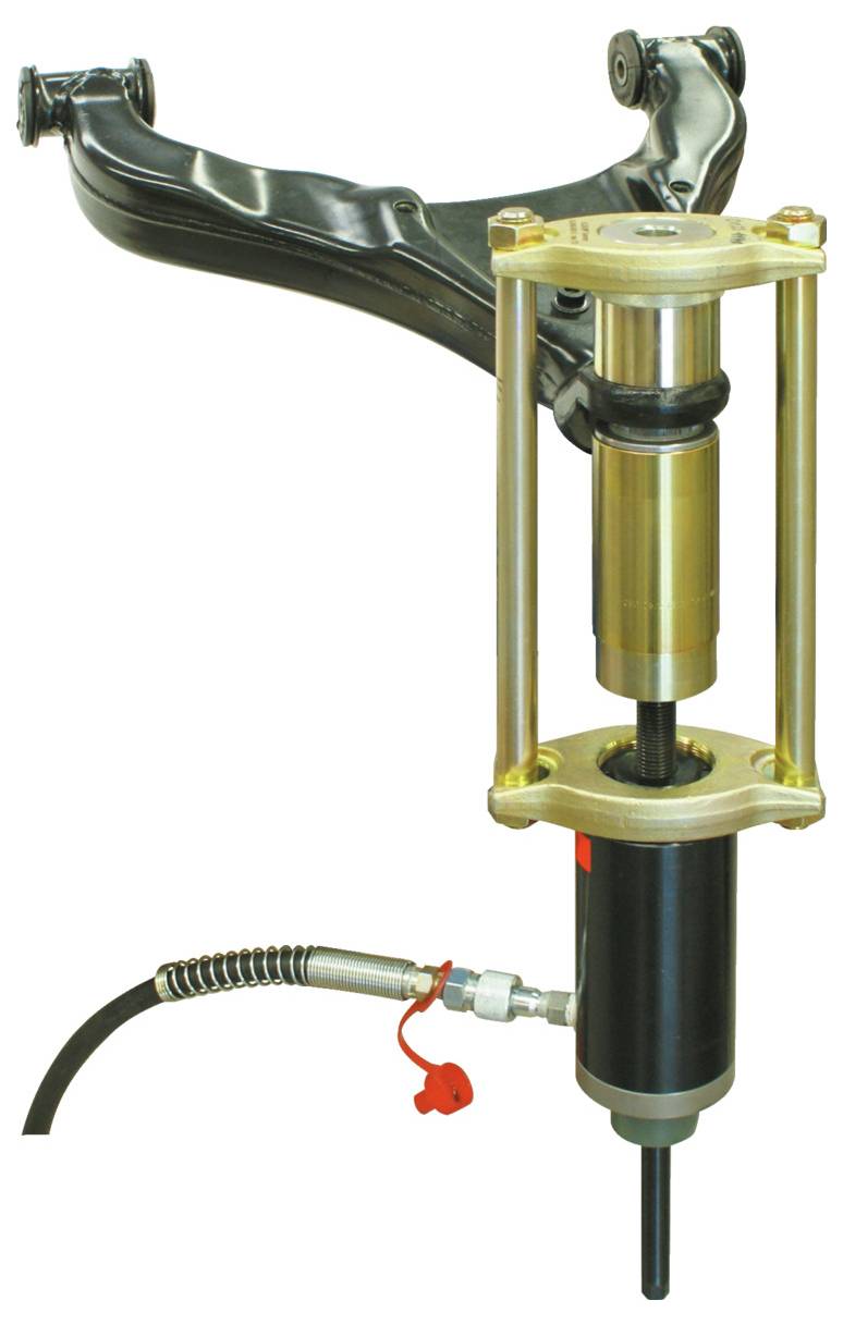 En mekanisk enhet med ett bronsfärgat hölje och svarta metallkomponenter, inklusive en hydraulcylinder och en arm, troligen använd för bilreparation.