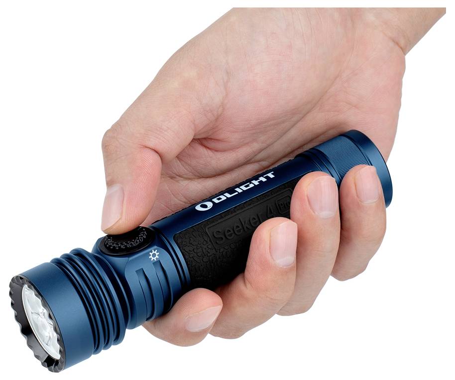 En hand håller en blå ficklampa med orden "OLIGHT" och "Seeker 4" på den, tummen trycker på en svart knapp nära framsidan.