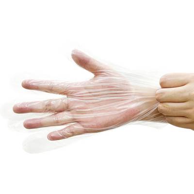 En persons hand täcks med en transparent plasthandske, vilket illustrerar korrekt teknik för att sätta på handskar för hygien eller livsmedelshantering.