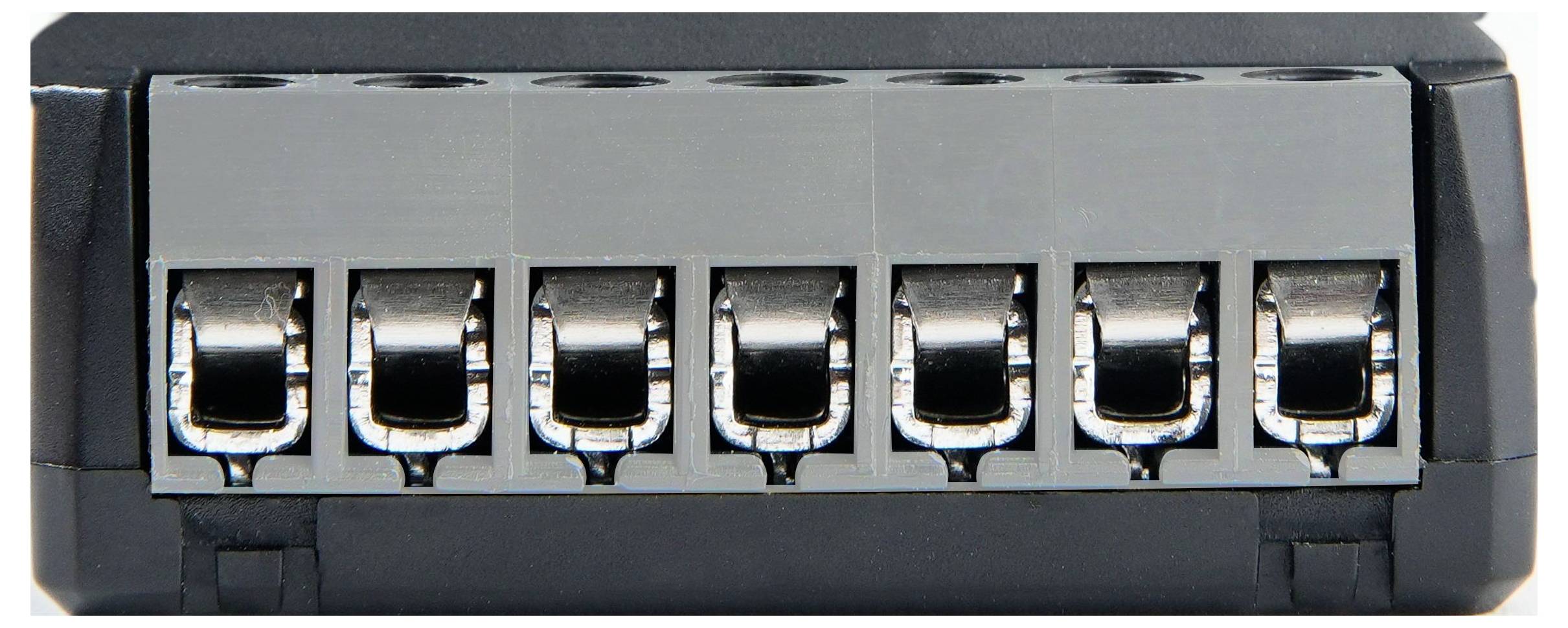 En 6-slots terminalblock med metallkontakter för elektriska anslutningar.