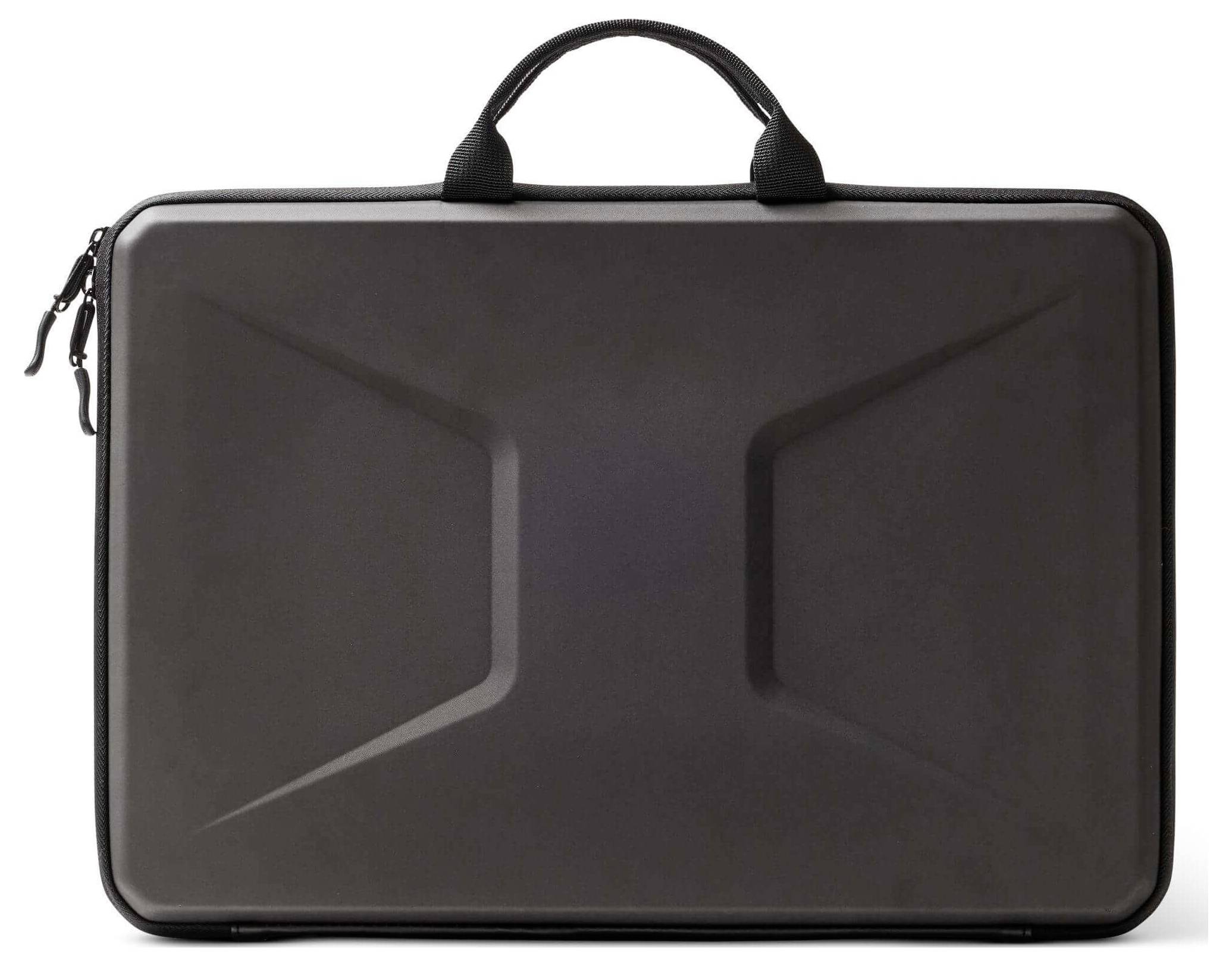 En svart, hårdskalkad portfölj med ett handtag och med en geometrisk design på framsidan.