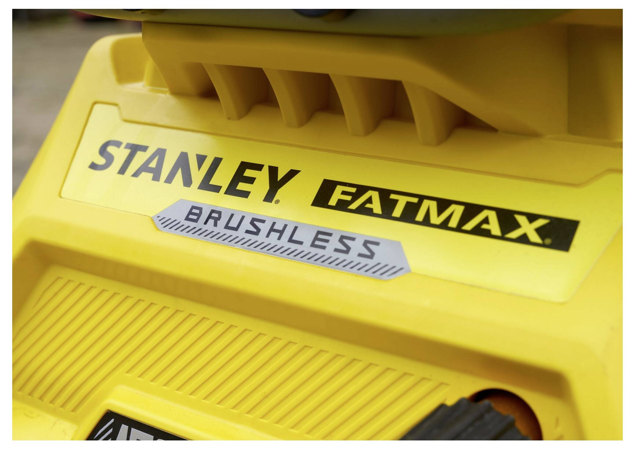 Närbild av ett gult elverktyg med etiketterna "STANLEY FATMAX" och "BRUSHLESS", vilket framhäver märket och typen.