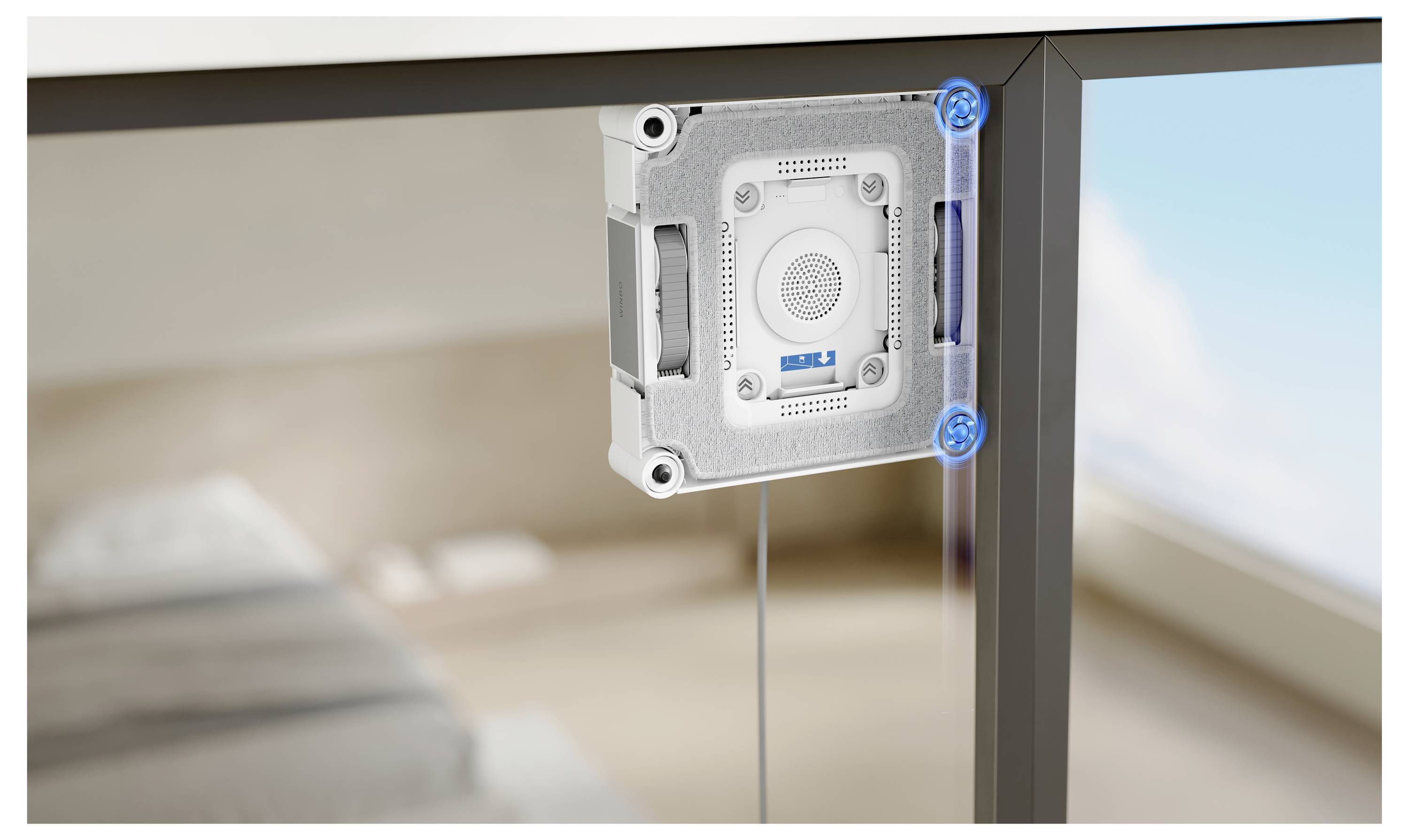 En vit elektronisk enhet är monterad under ett glaskbord nära ett fönster, med kablar som sträcker sig nedåt.
