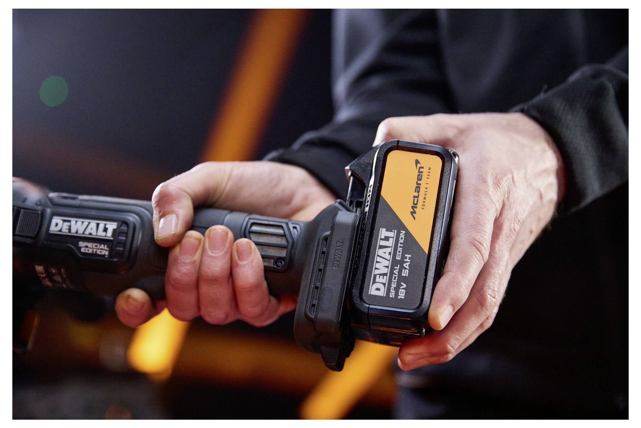 Närbild av en person som håller ett DeWalt batteridrivet verktygshandtag med batteripaketet framträdande fäst.