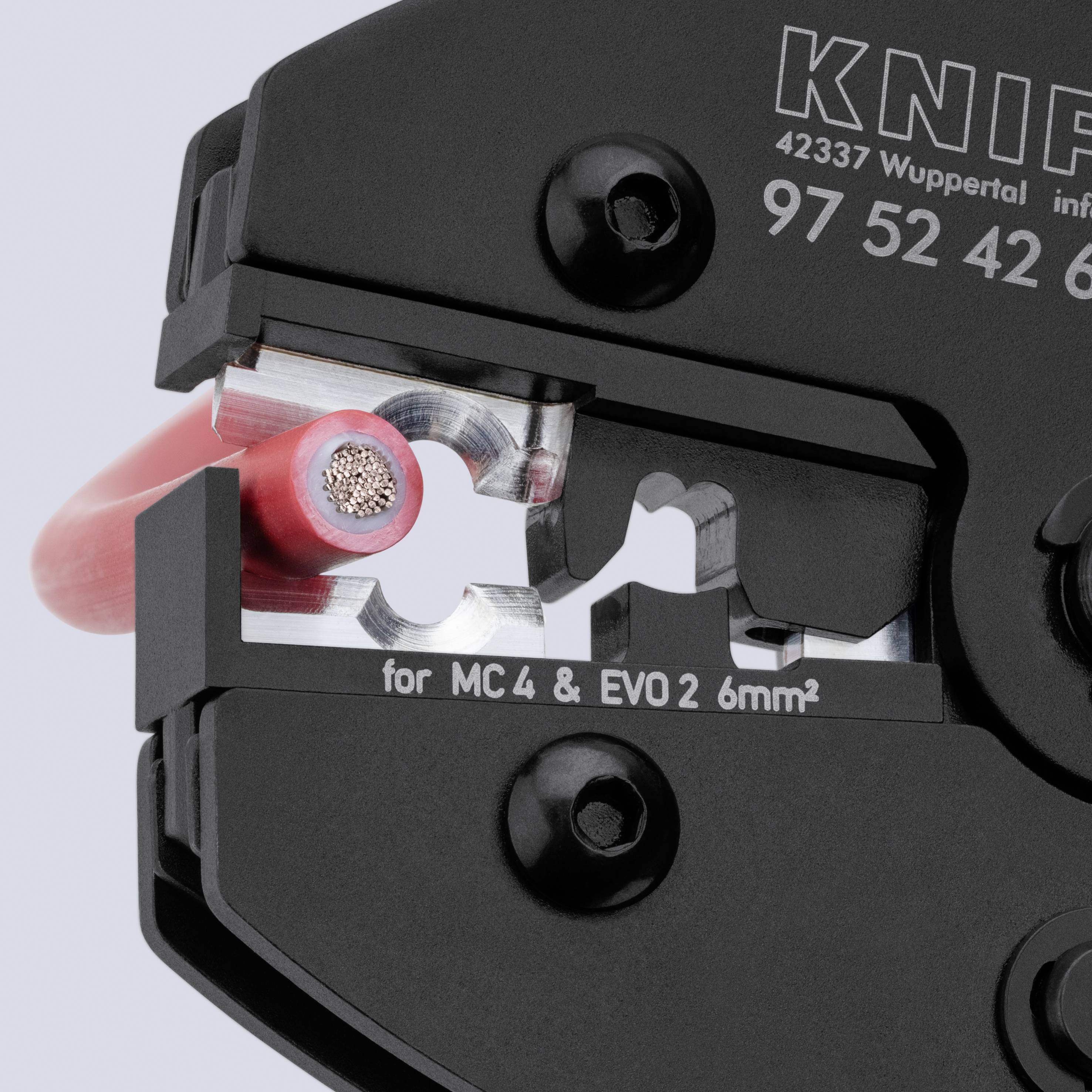 Närbild av ett kabelkrympningsverktyg som spänner en röd isolerad ledning, med märkningar för "MC4 & EVO2 6mm²" på verktygets kropp.