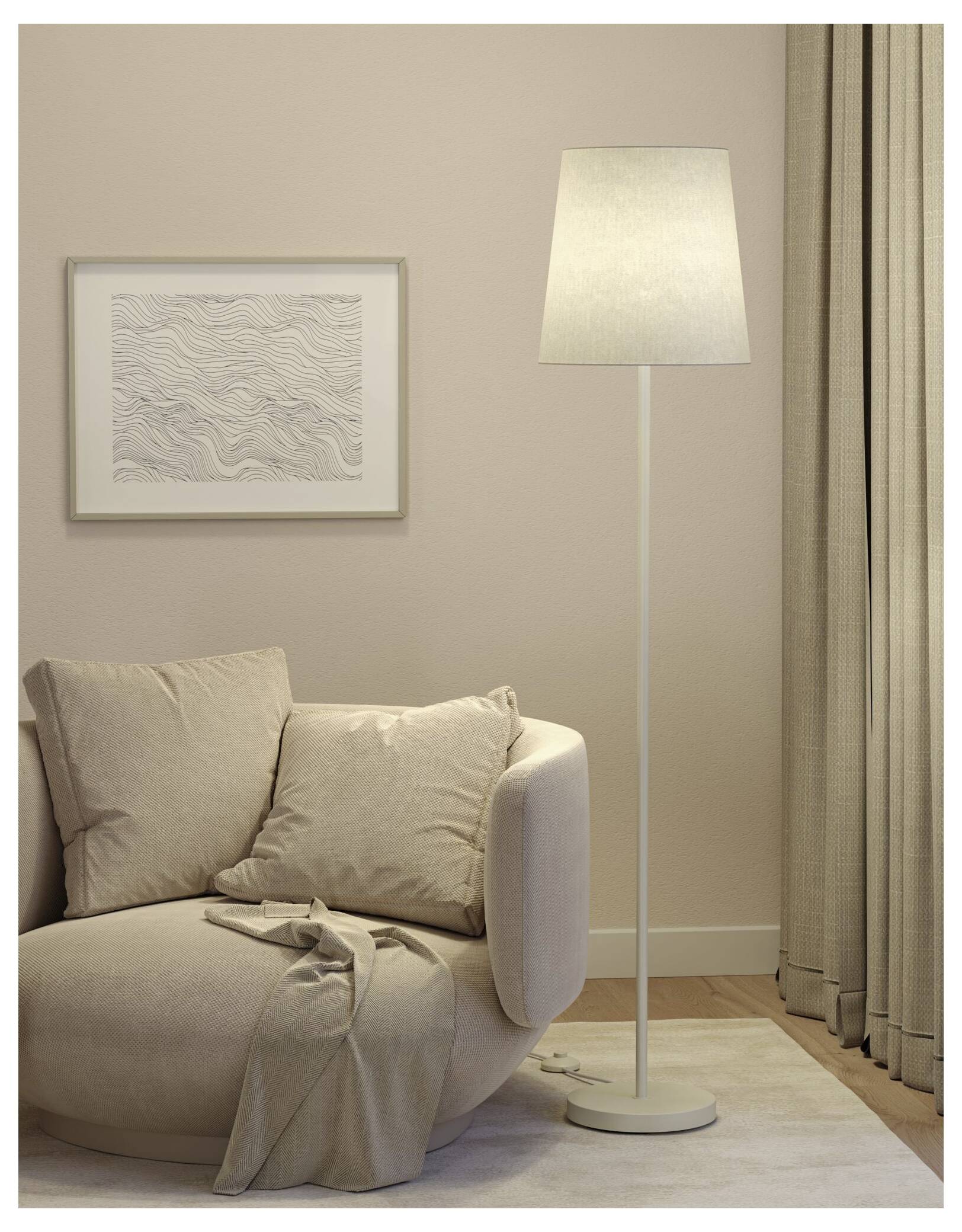 Mysig beige vardagsrumshörn med en soffa, golvlampa, inramad väggkonst och gardiner.