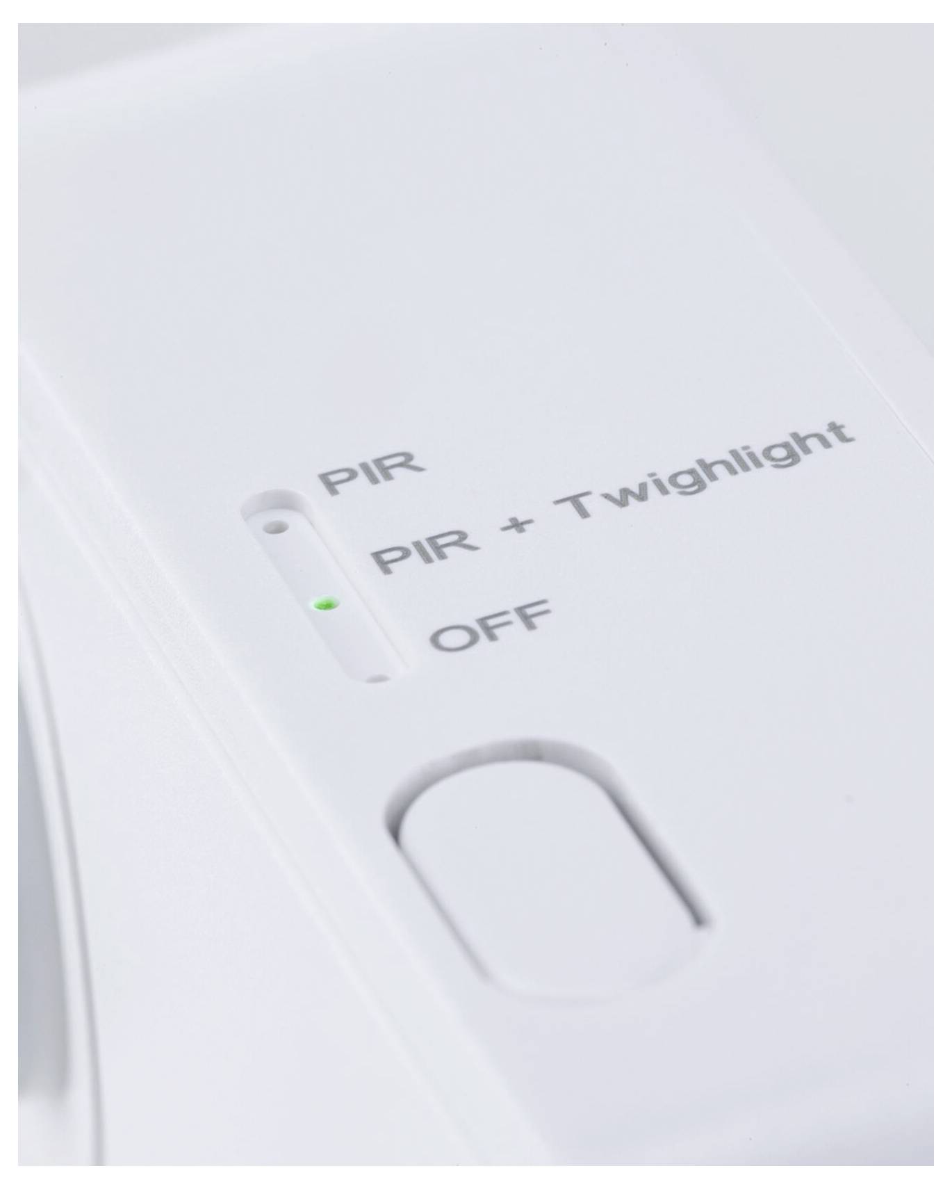 Vit enhetskontrollpanel med en lägesväljare märkt "PIR", "PIR + Twilight" och "OFF", med en grön indikatorlampa bredvid den aktuella inställningen.