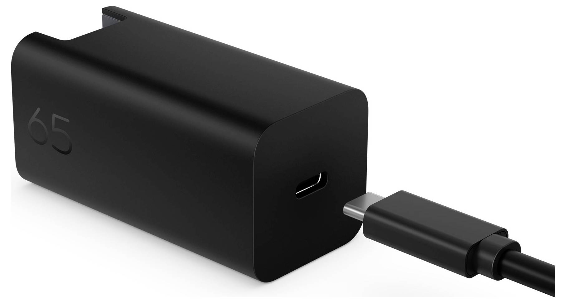 Svart 65W USB-C väggladdar med kabel ansluten till porten, visad på vit bakgrund.