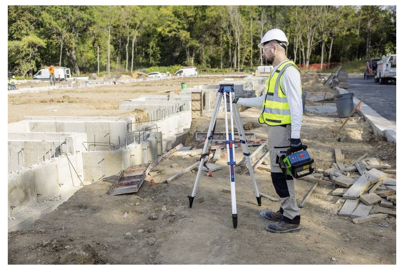 Konstruktionsmätare i säkerhetsutrustning använder ett stativmonterat instrument på en aktiv grundläggningsarbetsplats.