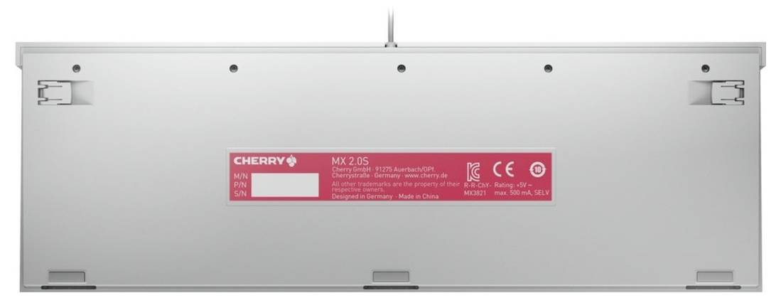 Bakvy av ett silvergrått datortangentbord med utfällbara fötter och en röd CHERRY MX 2.0S-produktetikett centrerad på undersidan.