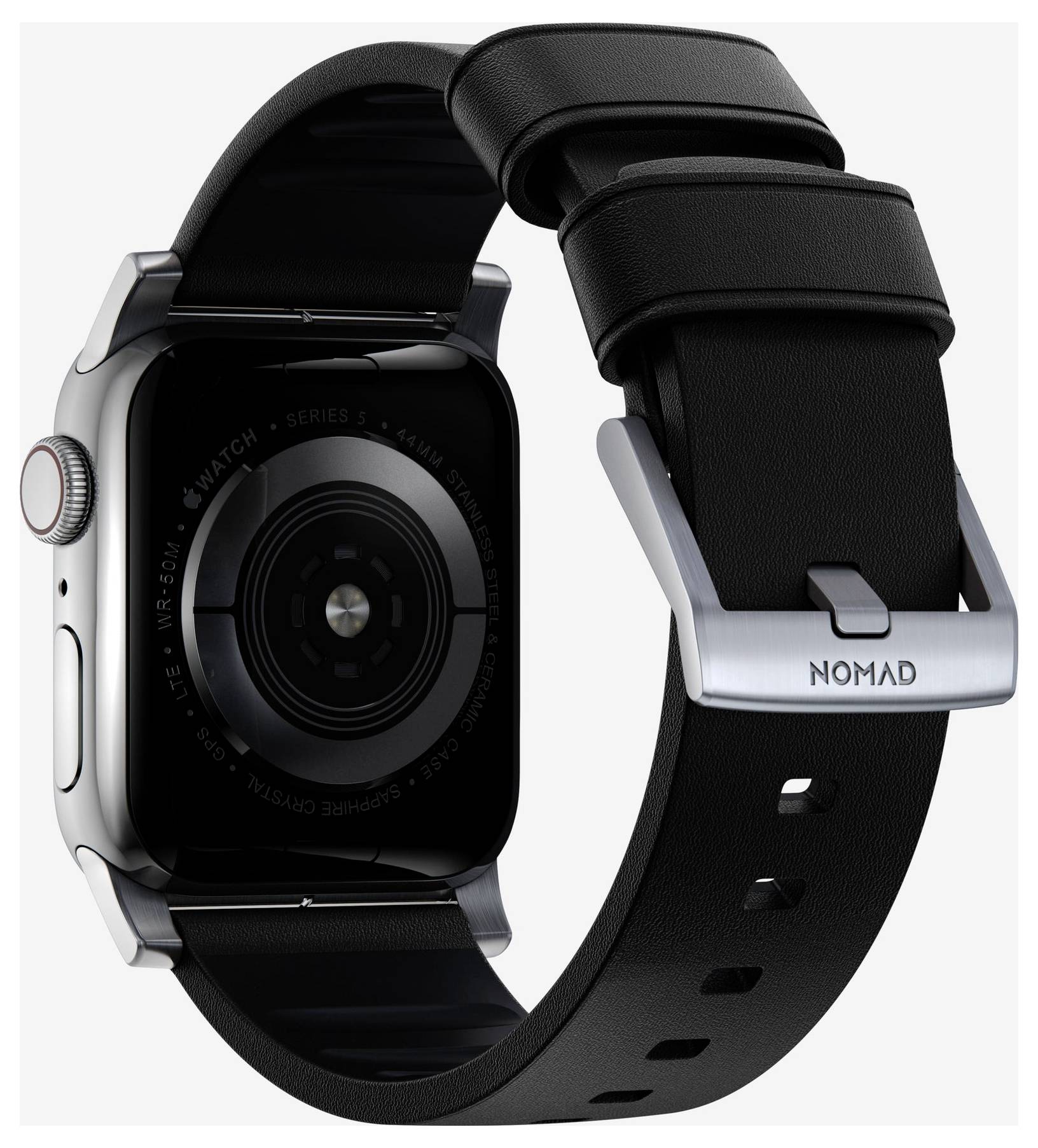 Bakvy av en silver Apple Watch med ett svart NOMAD-band, som visar urklockans sensor och bandbespänningen.