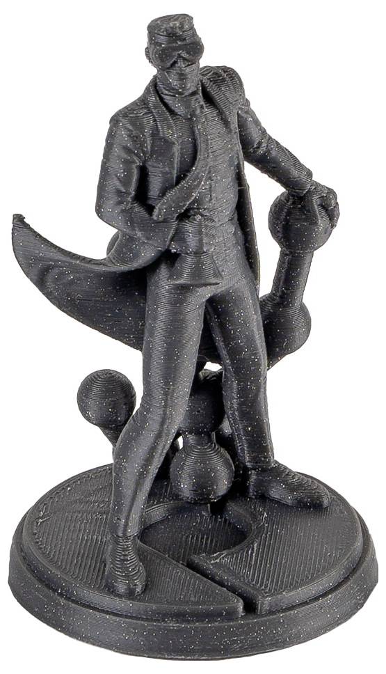 Svart figurin av en maskerad man i kappa och hatt, stående på en rund bas och holdande en käpp eller paraply.