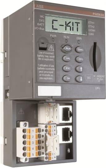 Närbilden av en ABB PM5630-styrenhet med en liten skärm som visar "C-KIT" och exponerade terminal- och Ethernet-portar nedan.