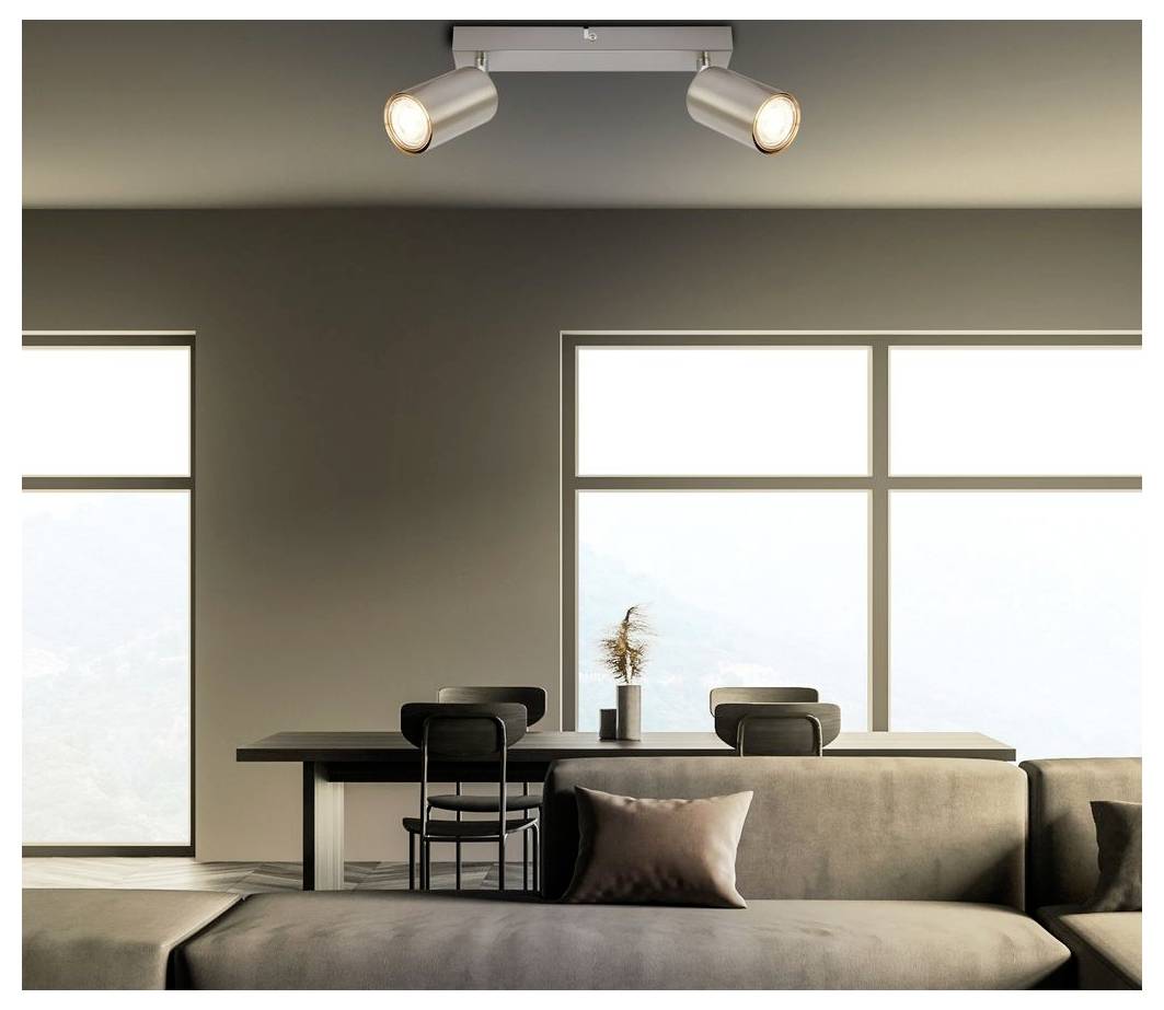 Modernt minimalistiskt vardagsrum med soffa, matbord, stolar, stora fönster och takspotlights i mjuka neutrala toner.