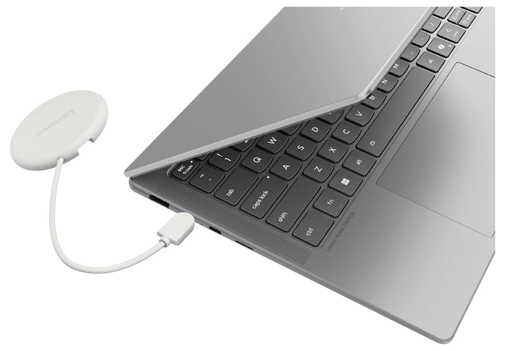 En bärbar dator ansluten via kabel till ett litet runt trådlöst tillbehör, vilket tyder på en adapter eller mottagare inkopplad i datorn.