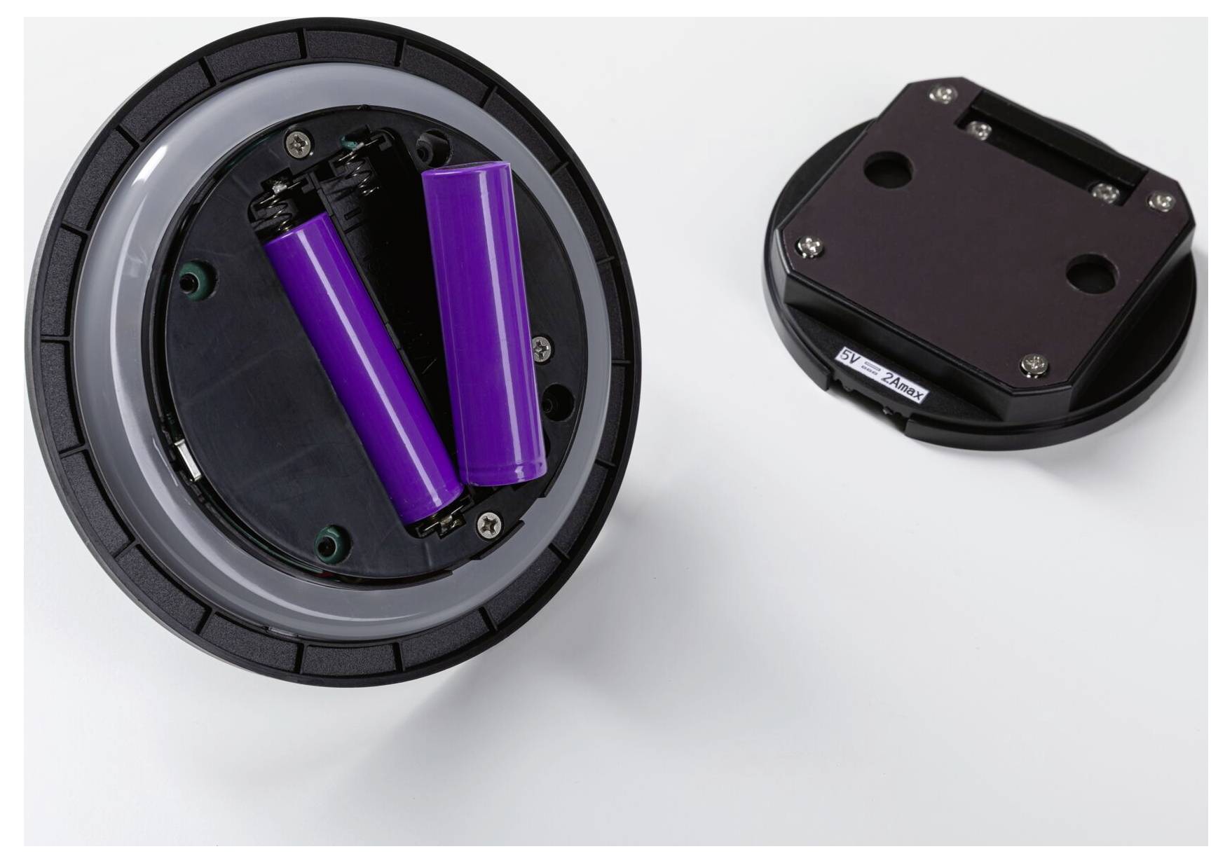Öppna batterifacket med två lila batterier visade bredvid det avmonterade locket.