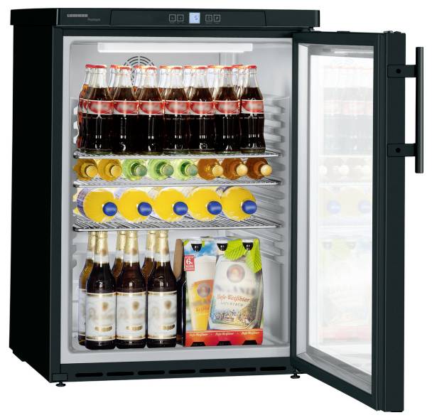 Öppen dryckeskyla fylld med ett sorterat utbud av flaskade drycker och burkar på trådöppna hyllor, dörr öppen åt höger.