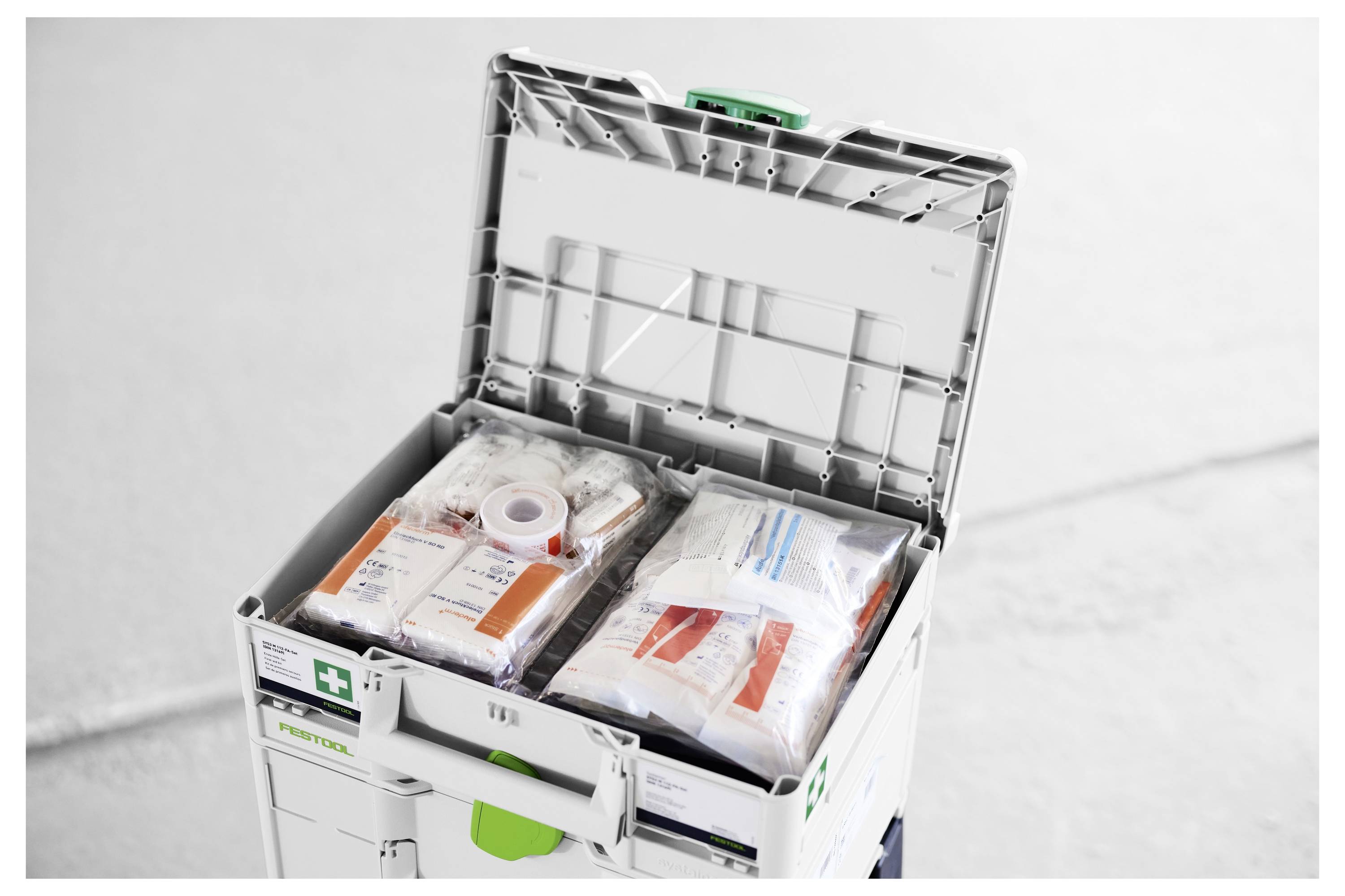 Öppna första-hjälpen-förrådet med organiserade medicinska bandage och förpackade nödförsörjningar inuti.