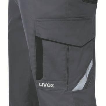 Närbild av mörkgrå arbetbyxor med lastficka, reflekterande kant och "uvex"-logotyp