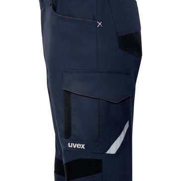 Närbild av marinblå arbetbyxor med lastfickor och reflekterande detalj, märkt "uvex".