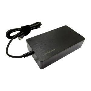 Svart rektangulär bärbar datoradapter med ansluten kabel och spiralvind sladd på vit bakgrund.