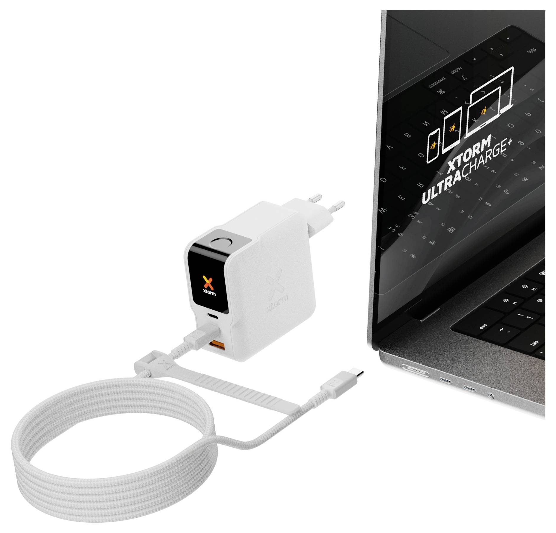 Vit Xtorm USB-C väggladdarare med tillkopplad kabel bredvid en bärbar dator, som visar "XTORM ULTRA CHARGE" på skärmen.