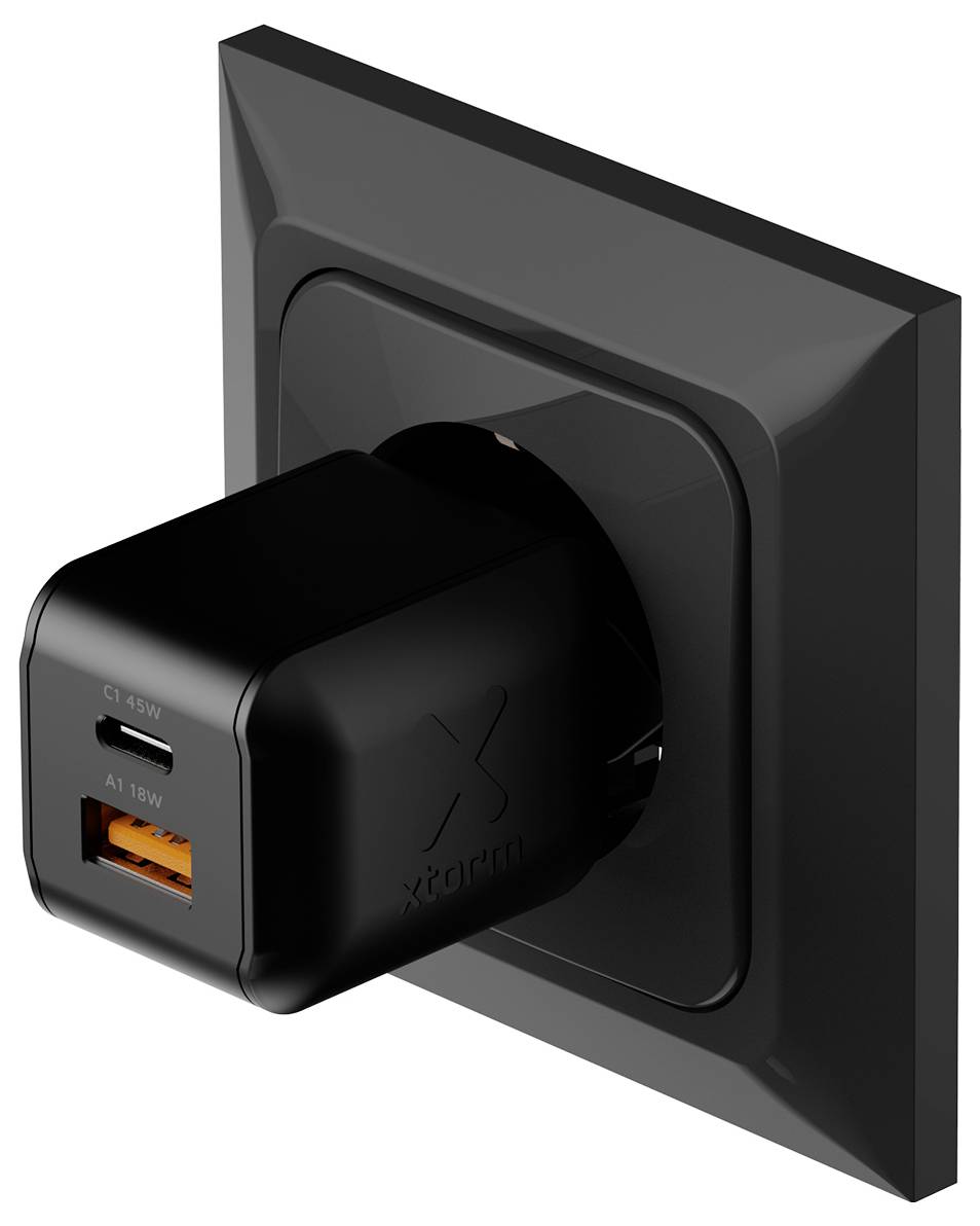 Svart väggkontakt-laddare med USB-C och orange USB-A-portar instickad i ett vägguttag